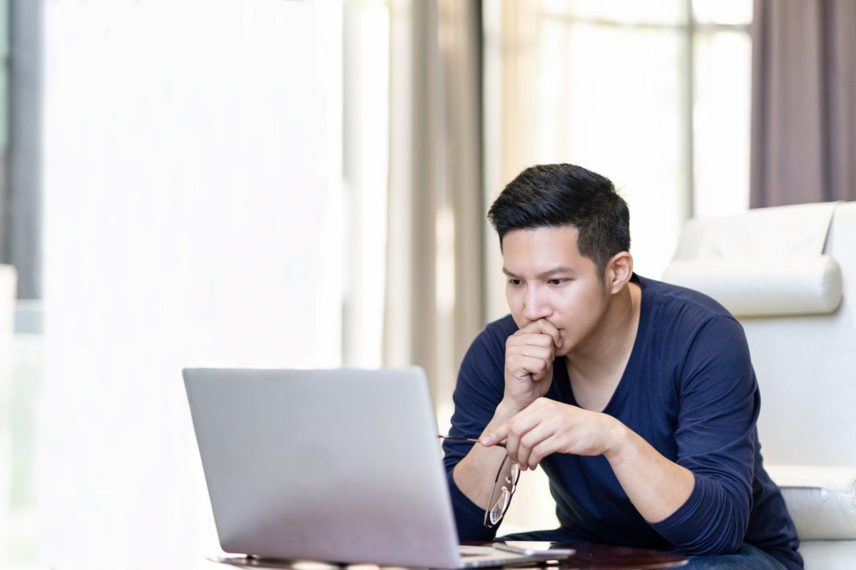 Dr. Avery Arora is a top doctor for hand surgery in Macomb, Michigan. In this image, a man is looking intensely at a computer. Research your options for top hand doctors online.