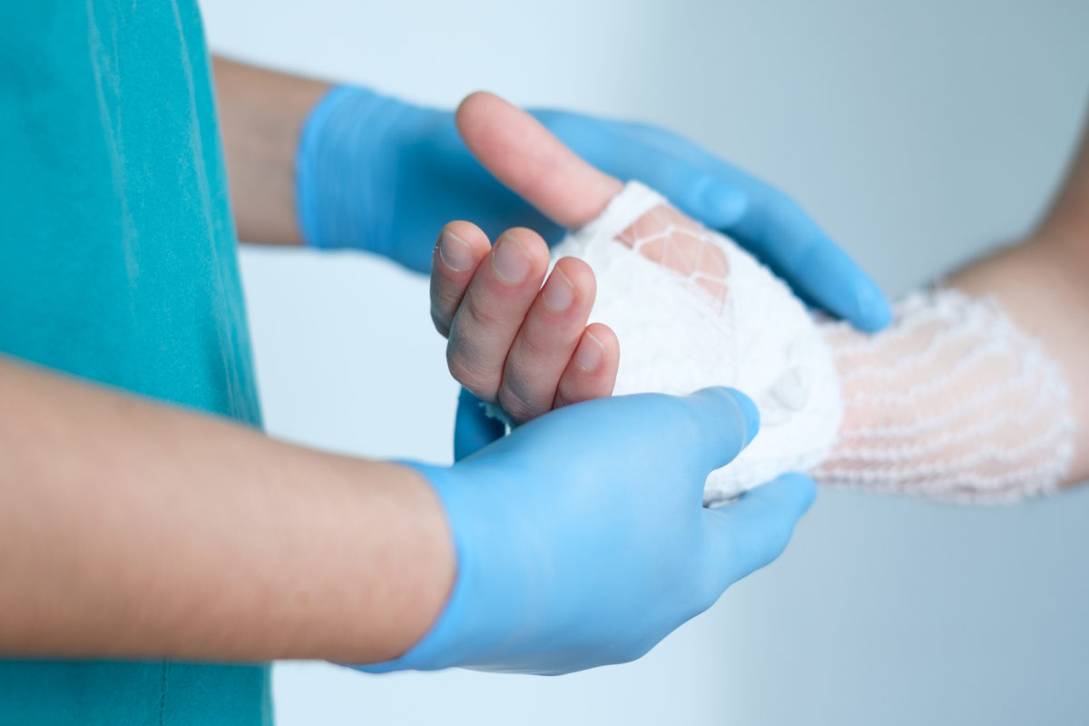 If you are looking for a hand surgeon in Howell, Michigan, answering common questions may help. This is a closeup image of a surgeon wrapping a patient's hand.
