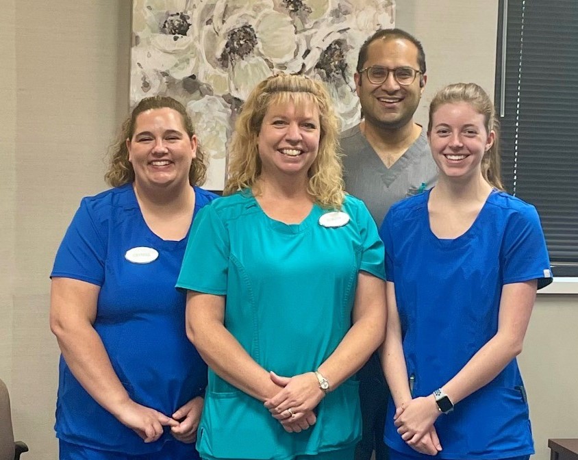 Dr. Avery Arora, a hand doctor in Macomb County, Michigan, is shown here with three members of his team.